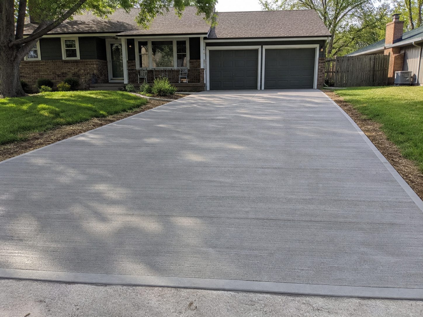 Finished residential concrete driveway in Lee's Summit, MO — clean broom finish and strong curb appeal